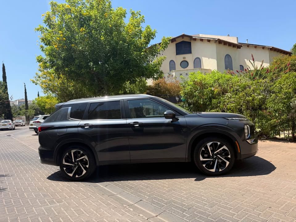 רכב SUV שחור חדש בחניון לבנים ליד בניין בהיר